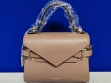 un petit sac à main beige posé sur une table blanche