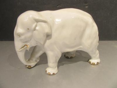 porcelain figurine of an elephant on a table with a gray background