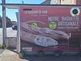 un panneau publicitaire accroché sur la façade d'un immeuble, faisant la promotion d'une baguette