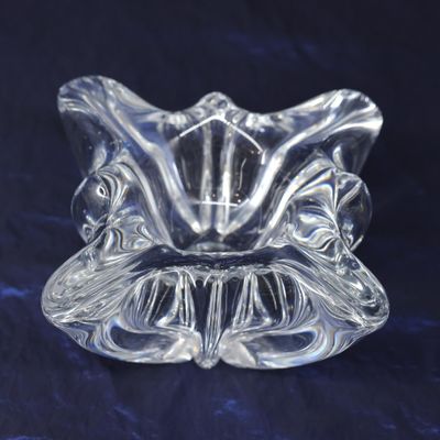 a close up of a clear glass candle holder on a blue background