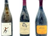 trois bouteilles de vin posées les unes à côté des autres sur une surface blanche