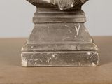 a statue of a man sitting on top of a wooden table