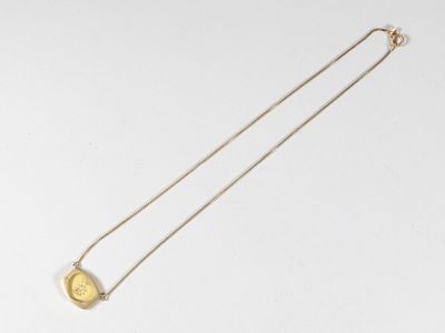 gros plan d'un collier en or sur une surface blanche