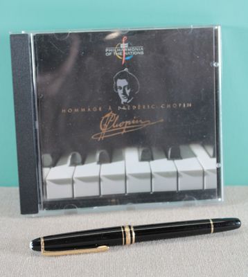 the pen is sitting next to a cd with a picture of a man ' s face on it