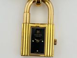 an image of a close up of a gold watch with a lock on it