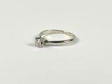 a close up of a diamond ring on a white surface