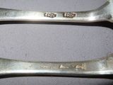 two spoons that are sitting next to each other on a table