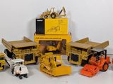 beaucoup de petits engins de chantier en jouets posés sur la table