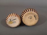 two baseballs sitting on top of each other on a table