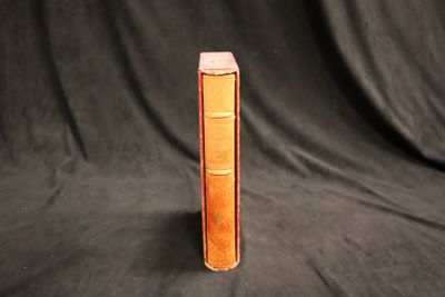 un livre marron posé sur un tissu noir