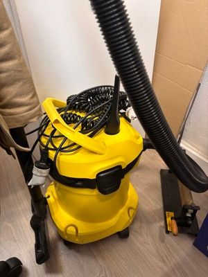 a vacuum that is sitting on the floor next to a chair