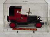 a red and black toy truck in a clear box