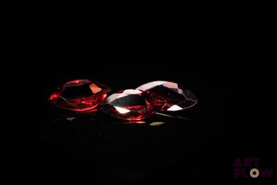 a close up of a pair of red diamonds on a black surface