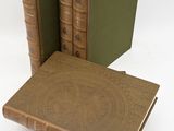 three books are stacked on top of each other on a white surface