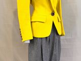 un mannequin vêtu d'une veste jaune et d'un pantalon gris