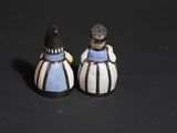 two salt and pepper shakers sitting on a black surface