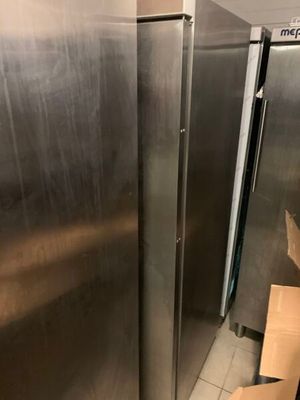 deux réfrigérateurs en acier inoxydable dans une pièce où se trouvent des cartons par terre