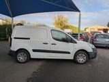 a white van parked in a parking lot under a blue umbrella