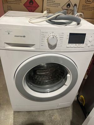 une machine à laver surmontée d'un sèche-linge