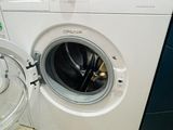 une machine à laver posée sur le sol