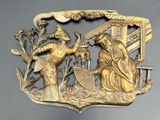brass plate depicting a scene of a man and a woman in a garden