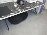 une photo d'une table sale sur laquelle se trouve une bouteille de bière
