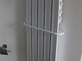 a radiator in the corner of a bathroom next to a toilet