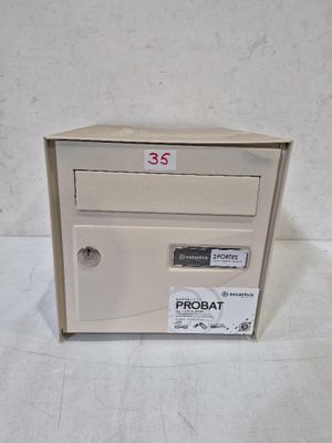 une boîte aux lettres blanche sur laquelle est collé un autocollant noir et rouge