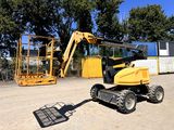 une petite machine jaune garée sur la terre battue