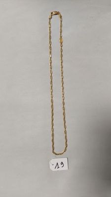 un collier à chaîne en or orné d'une petite étiquette blanche
