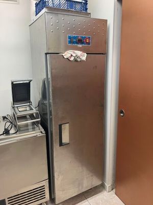un réfrigérateur argenté dans une pièce dont la porte est marron