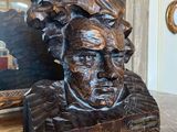une statue représentant un homme assis sur une table, à côté d'un miroir