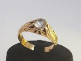 un gros plan d'une bague en or sertie d'une pierre