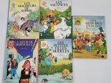 quatre livres pour enfants sont alignés sur une surface blanche