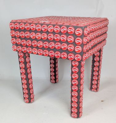 un tabouret fabriqué à partir de canettes de soda sur fond blanc