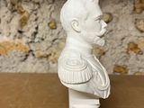 a white ceramic bust of a man on a wooden table