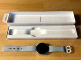 une montre connectée posée sur une table à côté d'une boîte