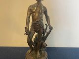 bronze statue of a man with a dog on a blue table