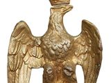 an image of a golden statue of a bird with a crown on it ' s head