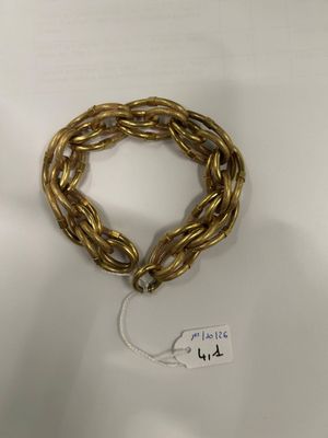 a close up of a gold bracelet with a tag on it