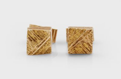 une paire de boucles d'oreilles carrées en or à la surface texturée