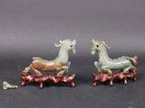 pair of green and brown figurines of two animals on a tree branch