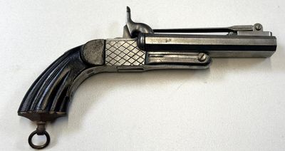 un vieux pistolet en forme de pistolet posé sur une surface blanche