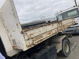 a man standing next to a dump truck in a parking lot