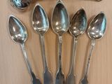 five spoons and a ladle sitting on a table