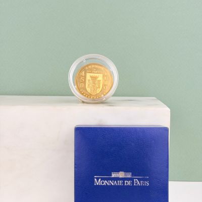 une pièce d'or posée sur un livre bleu