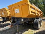 deux camions-bennes jaunes garés dans l'herbe