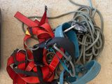 a black remote control sitting on the floor next to a pile of red and blue cords