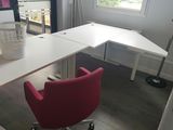 un bureau blanc avec une chaise rouge dans un coin