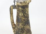 a brown and black pitcher with a silver lid